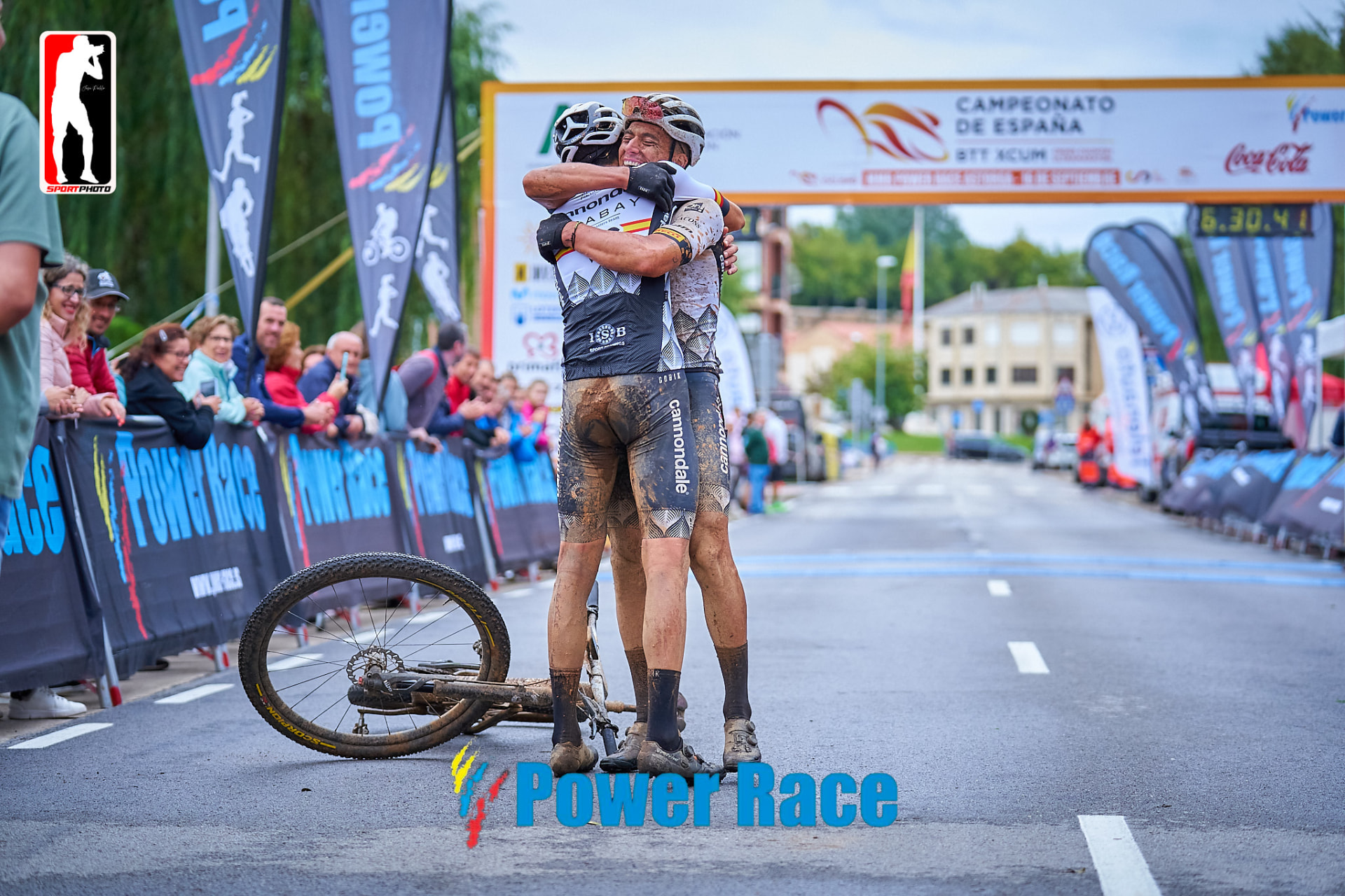 Dos corredores embarrados abrazándose en la meta de una Power Race